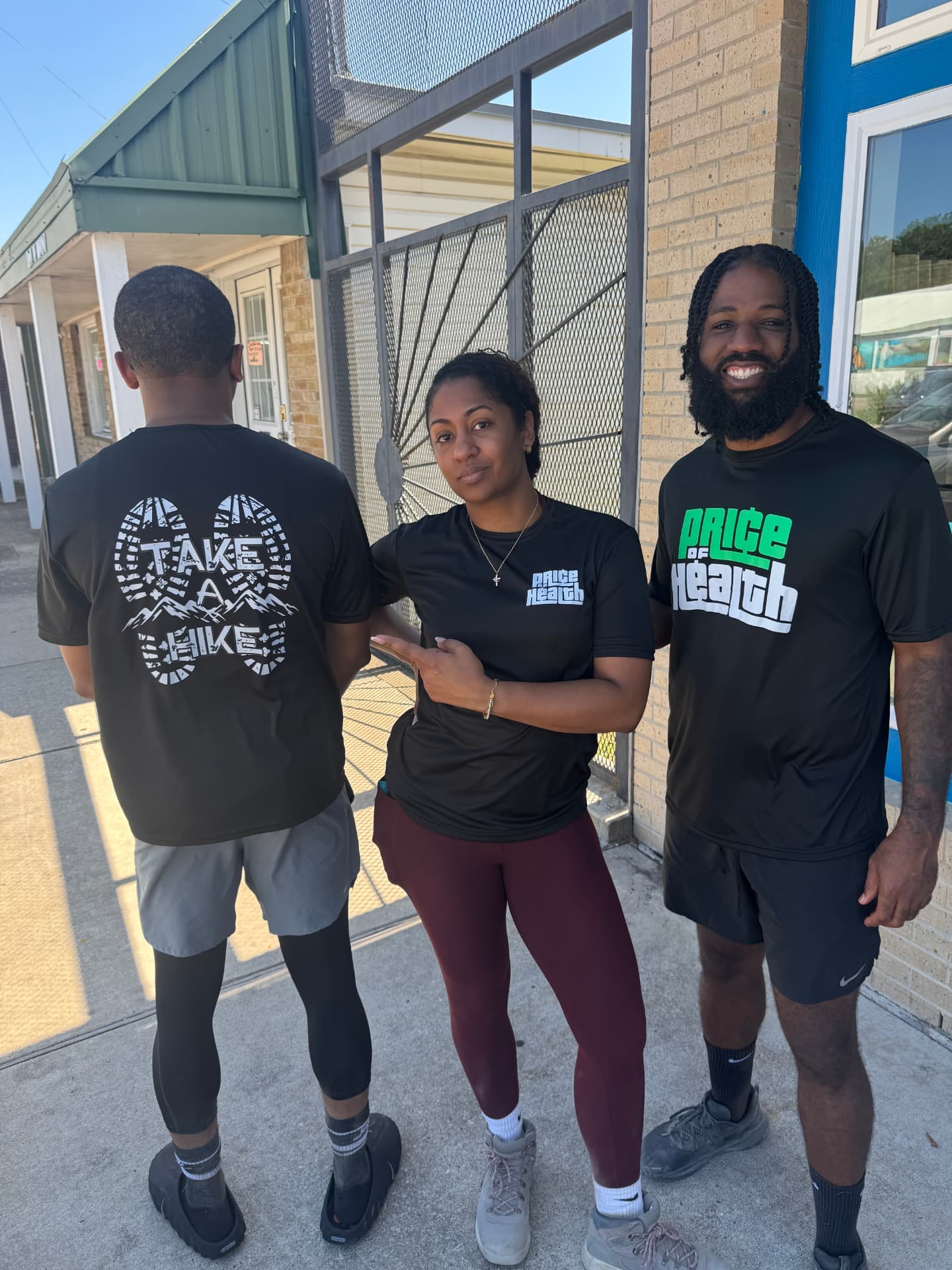 Three community members wearing Price of Health and Take A Hike apparel
